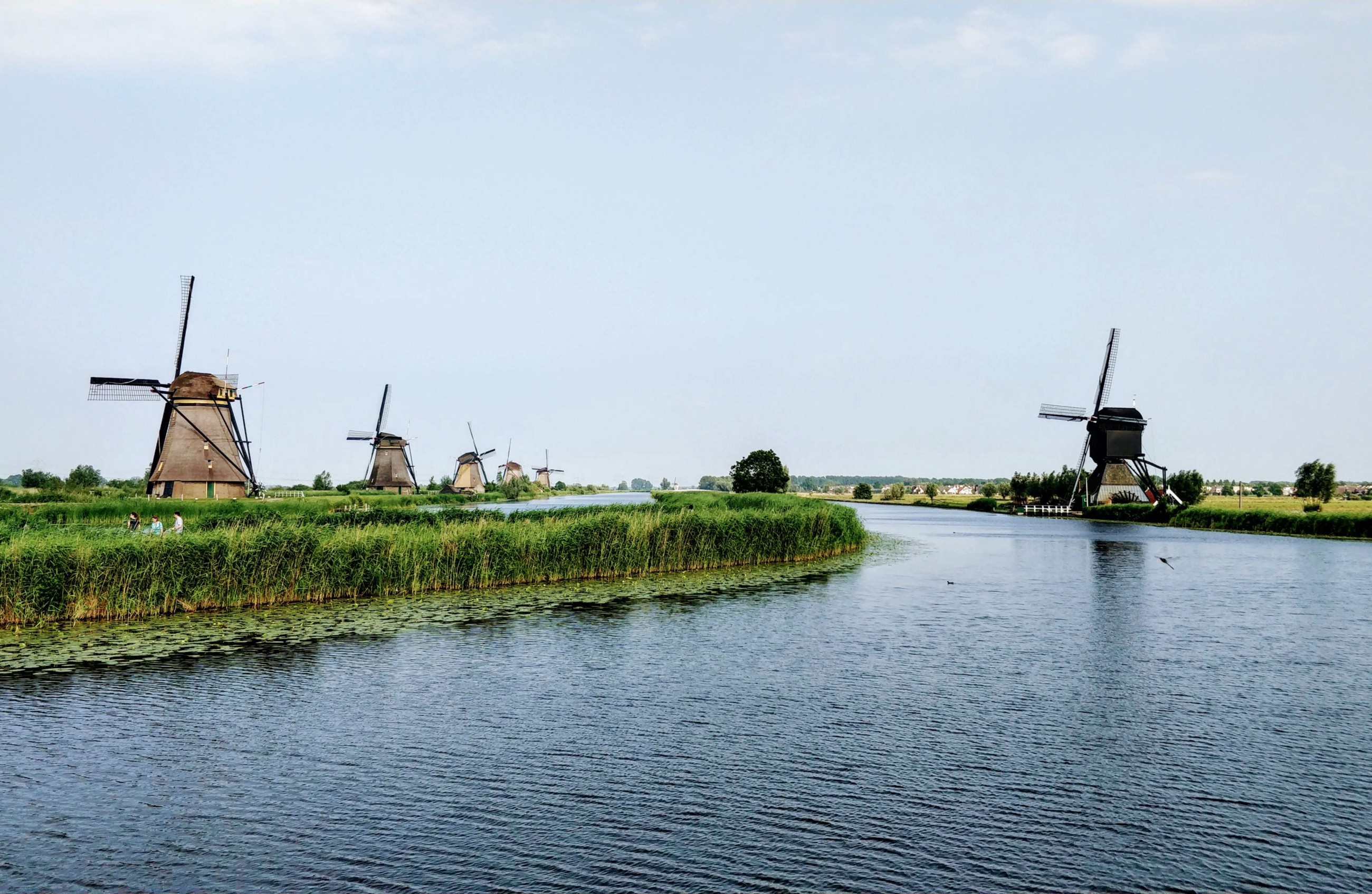 Photo called 'It’s Own Kind of Tranquility', displaying a series of windmills on either side of a 'water street (canal)' in Alblasserdam, The Netherlands